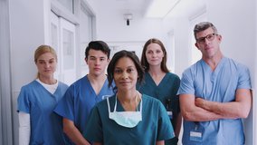 Portrait of smiling multi-cultural medical team standing in hospital corridor - shot in slow motion - Powered by Shutterstock - Get 15% off with code: PIKWIZARD15