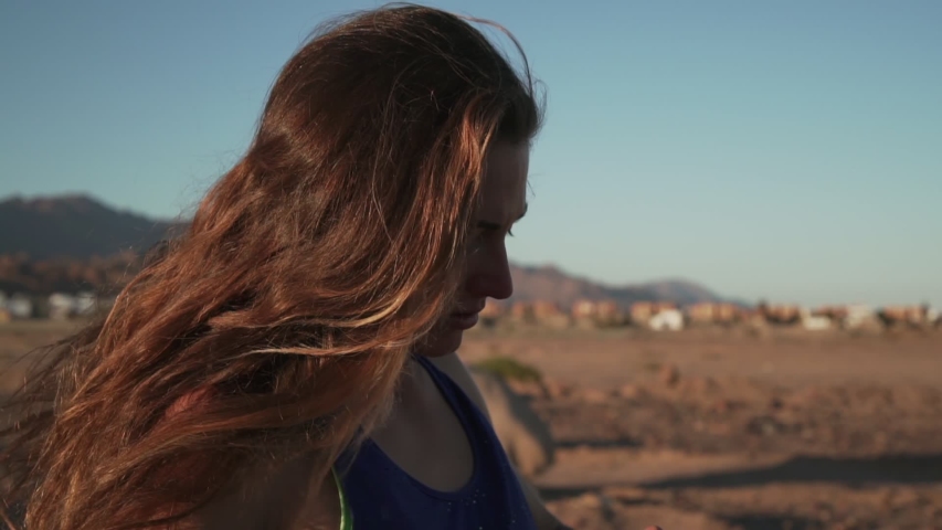 Sporty girl putting cap on her head in mount nature at sunset rapid slow motion