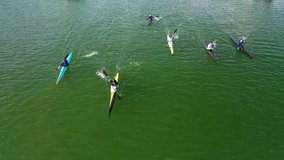 Aerial drone video of young athletes competing in canoe race in tropical lake with emerald waters
