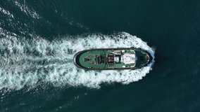Aerial drone video of tug assisting boat cruising near commercial container area of Perama, Attica, Greece