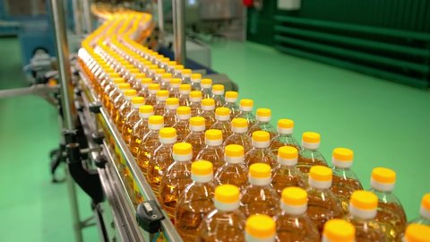 Sunflower oil in the bottle moving on production line.