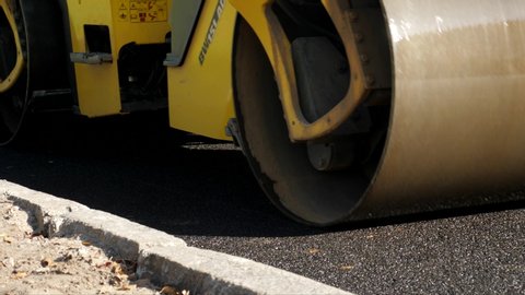 Heavy roller stack and press hot asphalt. Yellow road repair machine. Paver machine lay new bitumen on roads