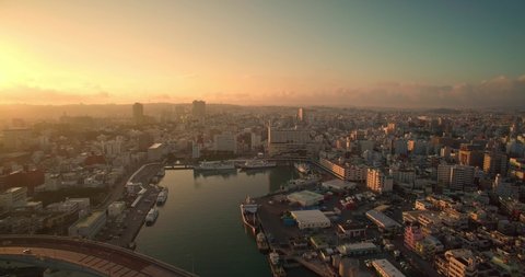 Aerial view of Naha city Okinawa Japan at sunrise with ocean views and Tomari port drone shot