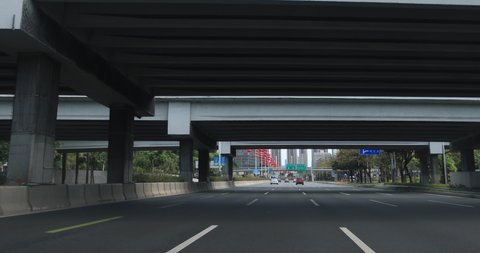 Shenzhen,China - February,2020:  Driving on the almost empty road in Shenzhen city during the outbreak of Novel Coronavirus . Few Vehicles and People on street, Everyone wear face mask. 