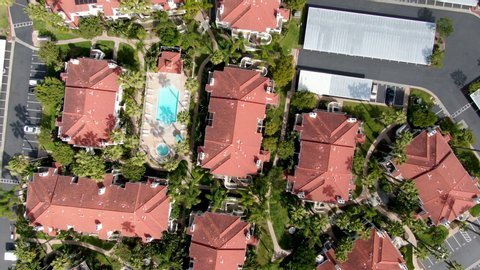 Aerial view of typical Southern California Spanish style residential condo, surrounded by nice garden with trees and swimming pool. San Diego, California, USA