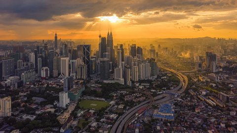Time Lapse: Day to night of cityscape during a golden sunset overlooking an elevated highway in Kuala Lumpur city. Malaysia. 