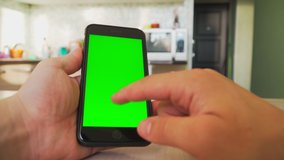 guy holding a smartphone in the hands of a green screen, hand of man keeps mobile smart phone with chroma key