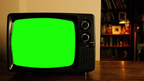 Retro 70s TV Set with Green Screen in the Living Room of a House at Night. Zoom In. You can replace green screen with the footage or picture you want. You can do it with “Keying” effect in AE.
