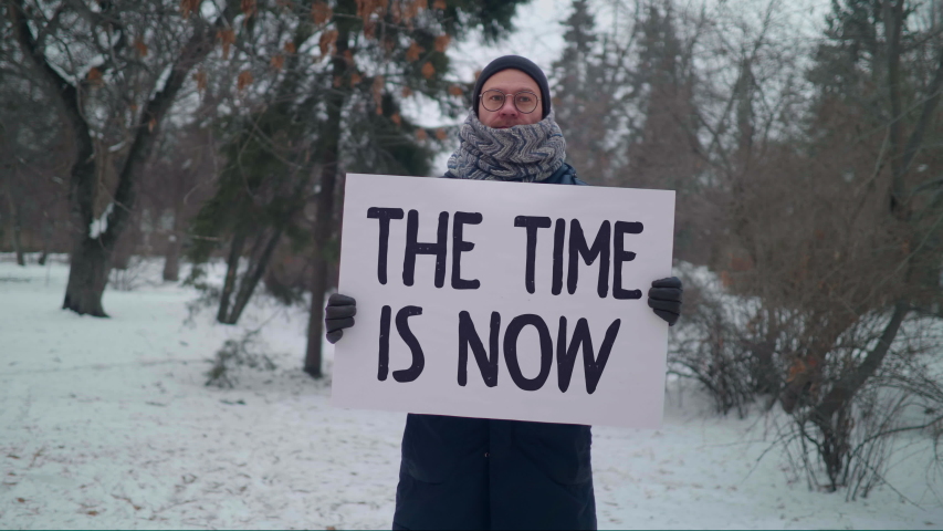 THE TIME IS NOW poster in the hands of male caucasian protester, picket, panoramic