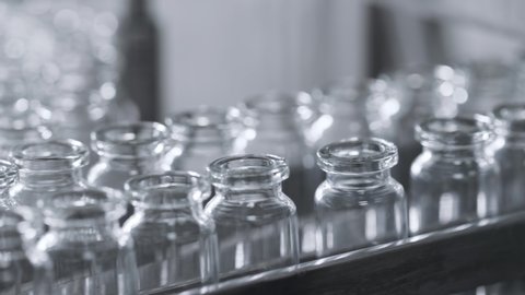 Medical Production of Drugs for Supply of Pharma Industry. Bottle Row on Conveyor Line of Factory. Manufacture Series of Sterile Materials for Pharmaceutical Medication or Cosmetics Mixtures Closeup