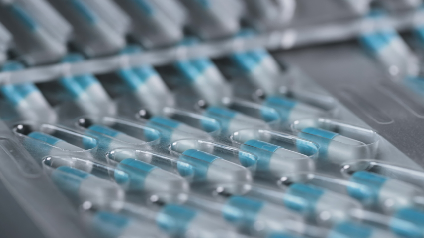 Manufacture of Drugs in Pills for Medical Supply of Pharma Industry. Filling Sterile Blister with Medication on Conveyor Line of Pharmaceutical Factory. Preparation and Production of Capsules Closeup | Shutterstock HD Video #1046960044