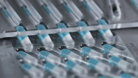 Manufacture of Drugs in Pills for Medical Supply of Pharma Industry. Filling Sterile Blister with Medication on Conveyor Line of Pharmaceutical Factory. Preparation and Production of Tablets Close-up