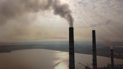Aerial view of high chimney pipes with grey smoke from coal power plant. Production of electricity with fossil fuel. - Βίντεο στοκ