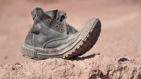 Old black boot in desert