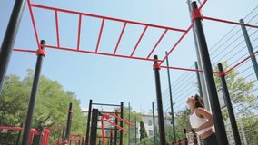 Young adult sportswoman training outdoors on city gym spot