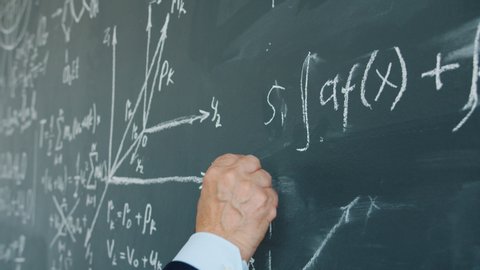 Slow motion of male hand underlining maths equation on chalkboard in class, professor is teaching at university. Science, theory and occupation concept.