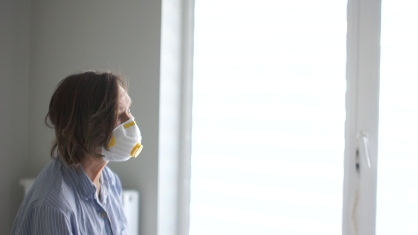 Doctor in a protective mask and glasses examines a woman with a flashlight. Pandemic threat, coronavirus threat. Covid19