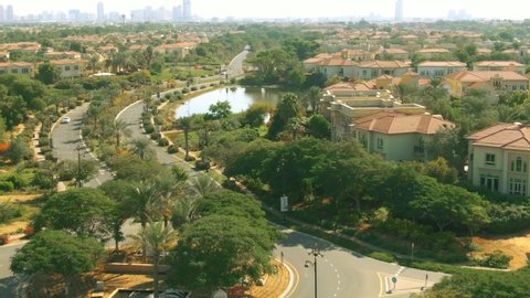 Aerial view of unknown luxury car driving along Jumeirah Islands community villas in Dubai, UAE