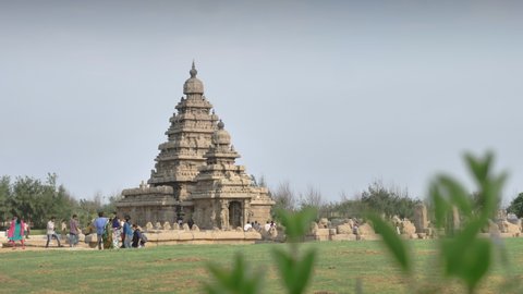A wide shot of tourist visiting Shore temple built by Pallava Dynasty situated at ancient Mahabalipuram or Mamallapuram UNESCO world heritage site in Tamil Nadu, India (November 2019)