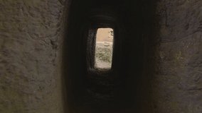 Forward push-in through rear tunnel to reveal Bet Maryam Church and courtyard in Lalibela, Ethiopia