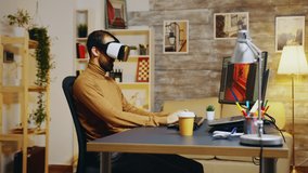 Game developer with virtual reality headset doing hand gesture while creating new graphics of the game.