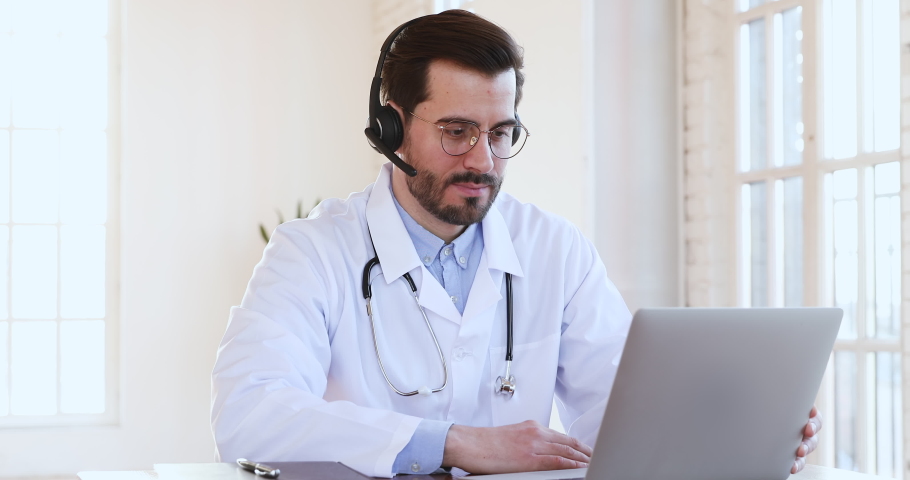 Friendly smiling professional male medic doctor in headset makes conference video call on laptop  consult patient look at camera, shows thumbs up recommend telemedicine online chat service app concept Royalty-Free Stock Footage #1047021466