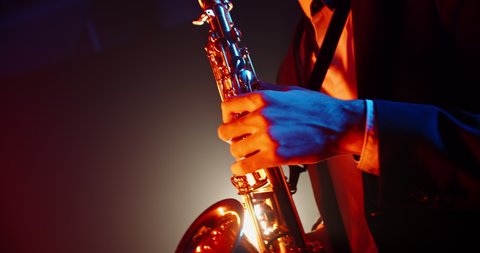 An experienced musician playing saxophone in jazz band. Saxophonist performing a solo in club stage - music, arts concept 4k footage