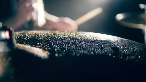Close up of a cymbal getting hit and splashes of water