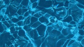 ripples on the surface of the transparent blue water in a pool close-up 4k slow motion