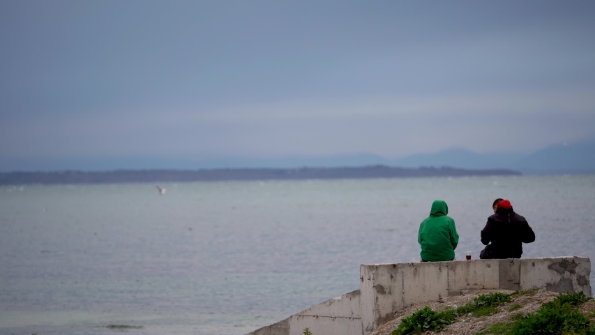 A couple looks at the lighthouse at sea