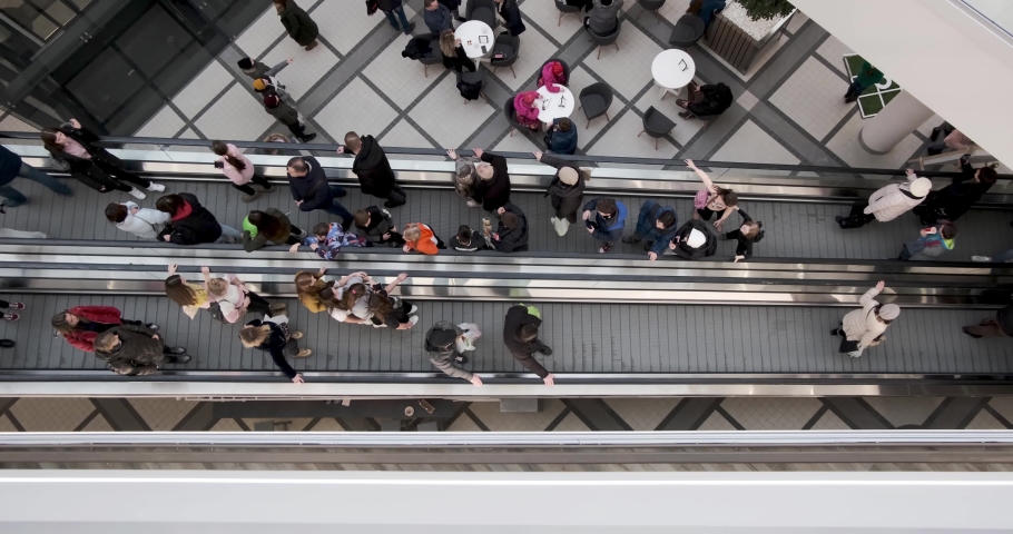 Crowd of people on an escalator in a large multi-storey layered shopping center. view from above | Shutterstock HD Video #1047044662