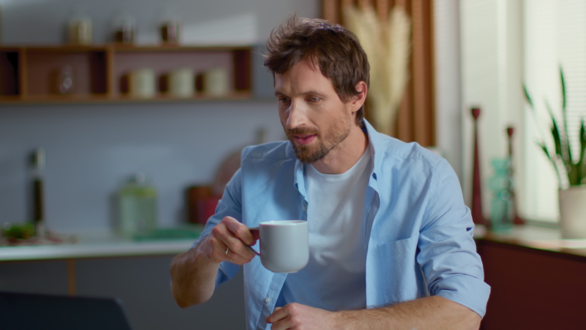 Portrait of handsome businessman working laptop computer at home. Business man drinking tea at home office. Focused man reading news on laptop on domestic kitchen in slow motion | Shutterstock HD Video #1047047488