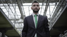 Bottom view of young confident Caucasian man in suit looking up and spreading hands. Handsome businessman in suit enjoying ownership of greenhouse. Lifestyle, business, production of organic food. - Powered by Shutterstock - Get 15% off with code: PIKWIZARD15