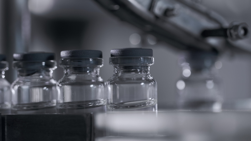 Medical Production for Drugs Supply of Pharmacy Industry Closeup. Manufacturing Bottle Row on Conveyor Line of Pharmaceutical Factory. Preparation Medication in Sterile Vials for Covid-19 Vaccine Royalty-Free Stock Footage #1047070675