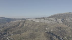 Flying high over mountains in Croatia Mediterranean Europe small town summer 10 bit dron ungraded footage
