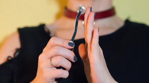 Close-up of a Wartenberg wheel on a woman's hand at a neurologist's doctor. Checks for pain sensitivity. Scientific concept.