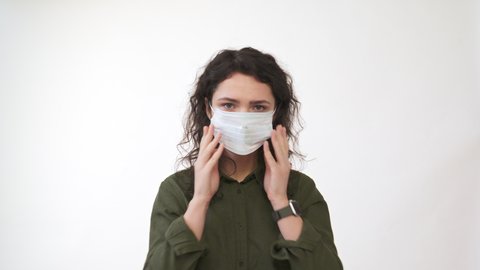 Young woman coughing. Wearing medical mask looking at camera. isolated on white  background. Close up front portrait. Health concept. 4k
