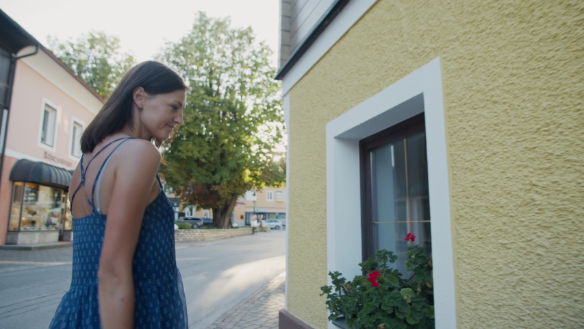 Woman admires flowers on a city street