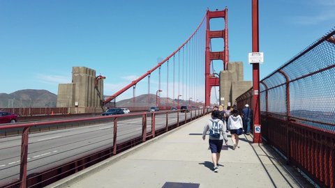 San Francisco, California, USA - August 2019: Golden Gate Bridge with pedestrian and car traffic, tourists walking on a sunny summer day