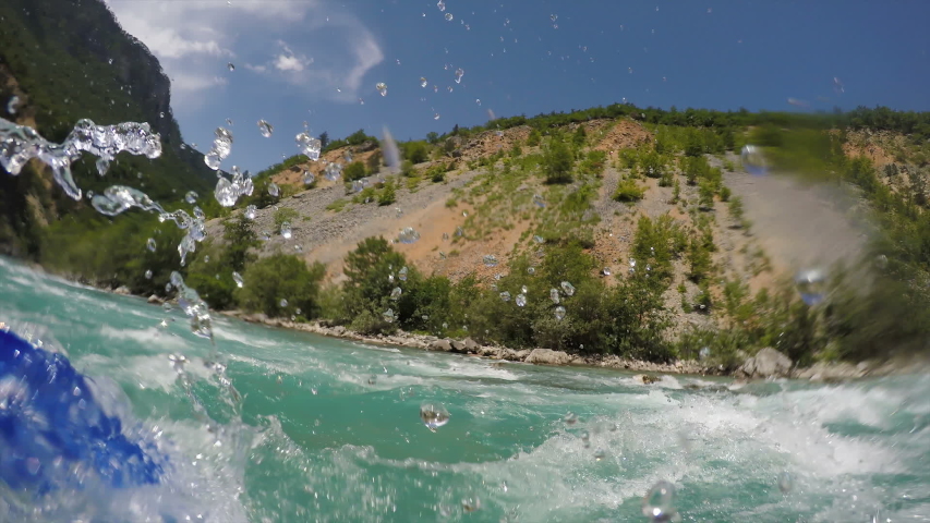 Paddling Through White Water Rapids. Whitewater Rafting Teams Descending Raging Rapids. POV Shot of White Water Rafting on Rough Water. Mountain River Flowing Through A Canyon.