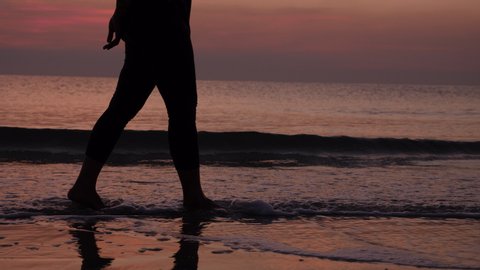 Close up women foot walking slow motion on the beach at sunrise