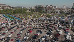 Video drone shot of people car parking to attend to morning flea market.