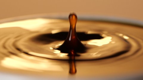 Close-up of Espresso coffee drop into the filled Cup from the coffee machine in slow motion