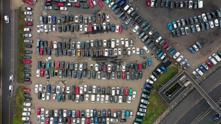 Aerial footage of a busy unmarked car park located in the Leeds City Centre, showing cars looking for parking spaces and the Leeds Ring Road at the side, located in the Leeds Centre West Yorkshire UK Royalty-Free Stock Footage #1047112963
