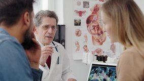 Handheld view of gynecologist consulting prognosis with young couple. Shot with RED helium camera in 8K  - Powered by Shutterstock - Get 15% off with code: PIKWIZARD15
