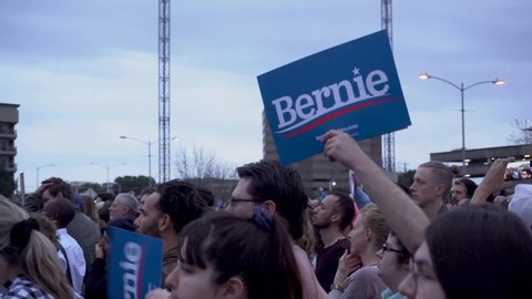 Austin, Texas February 23 2020: Man holds Bernie sign as people cheer while Bernie Sanders speaks ahead of the 2020 Texas Primary