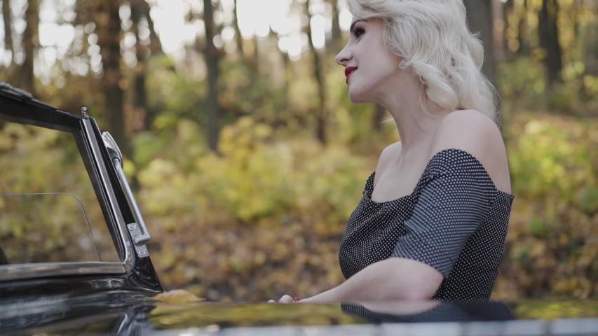 Profile portrait of beautiful lady smiles and looks on man at car. Slowly