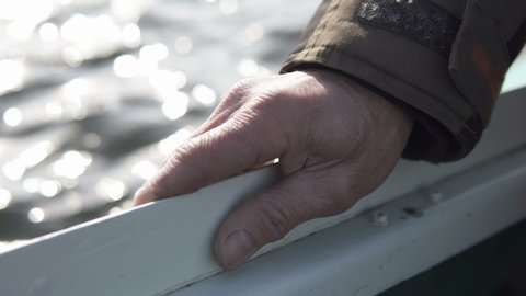 Hand of an old fisherman on board a boat