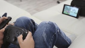 A blonde girl holds a joystick in her hands and plays a game console.