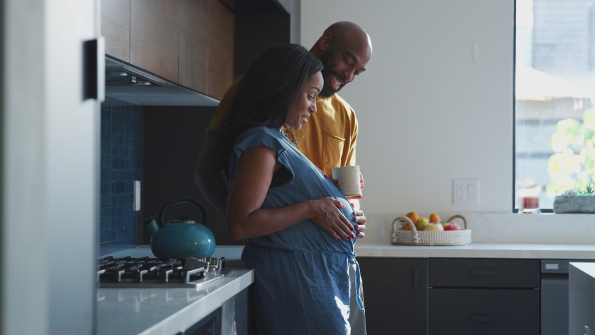 Loving african american husband with pregnant wife at home in kitchen feeling baby kick together - shot in slow motion
 Royalty-Free Stock Footage #1047139597